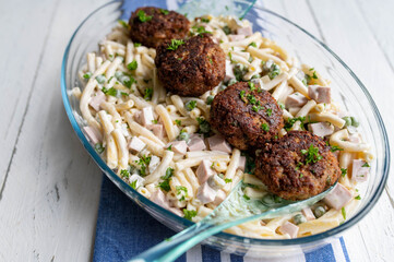 Traditional german dish with fried pork meatballs and homemade pasta salad in a bowl