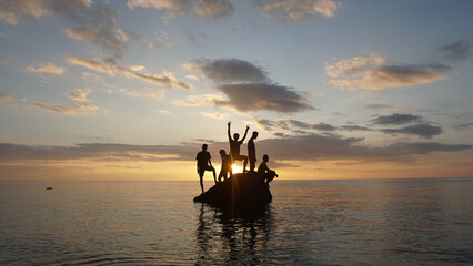 five man made it to the rocks sunset on the beach