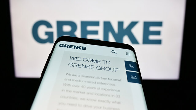 Stuttgart, Germany - 08-21-2023: Mobile phone with website of German leasing company Grenke AG on screen in front of business logo. Focus on top-left of phone display.