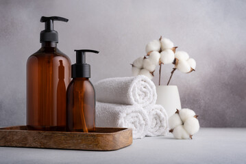 Stack of rolled white towels and dispenser bottles for spa and bathroom