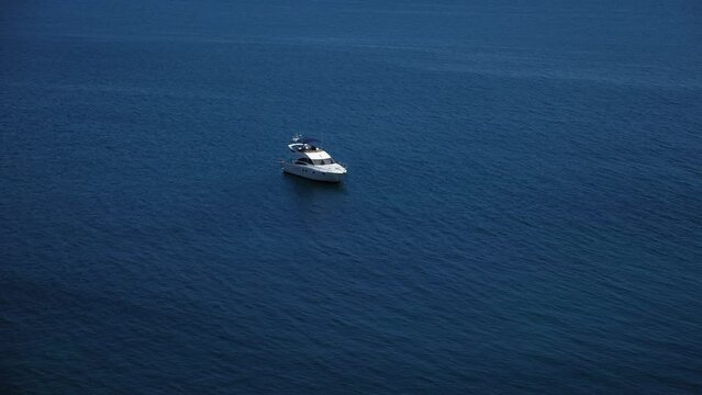 A small beautiful modern boat on the sea. Summer vacation on a yacht. Beautiful view of the blue sea and the yacht.