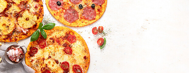 Different types of italian pizza on light background.