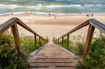 View to the seaside from old wooden stairs from a high coast on a sunny summer day in Jurkalne in Latvia, at the Baltic sea.
