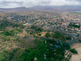 Fototapeta premium Aerial drone Tarrafal in Santiago Island, Cabo Verde showcase golden beaches, azure waters, and rugged mountains, it's a paradise for nature lovers. The charming town, historic sites