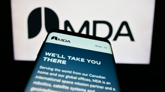 Stuttgart, Germany - 08-25-2023: Mobile phone with webpage of Canadian space technology company MDA Ltd. on screen in front of business logo. Focus on top-left of phone display.