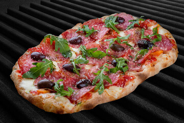 Pizza Diavolo with chorizo, rucola, jalapeno, chili, kalamata, pesto. Roman pizza rectangular on dark background