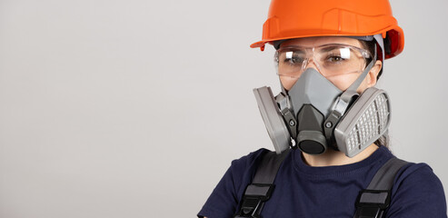 A woman wears a protective respirator with dust and gas filters on a white background. - obrazy, fototapety, plakaty