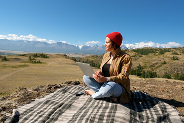 woman freelancer traveler working online using laptop and enjoying the beautiful nature landscape...