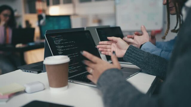 Closeup of programmers discussing new task, giving advice, managing IT project
