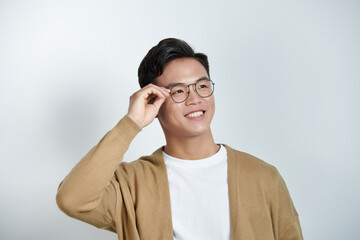 Handsome stylish young man touching eyeglasses and posing