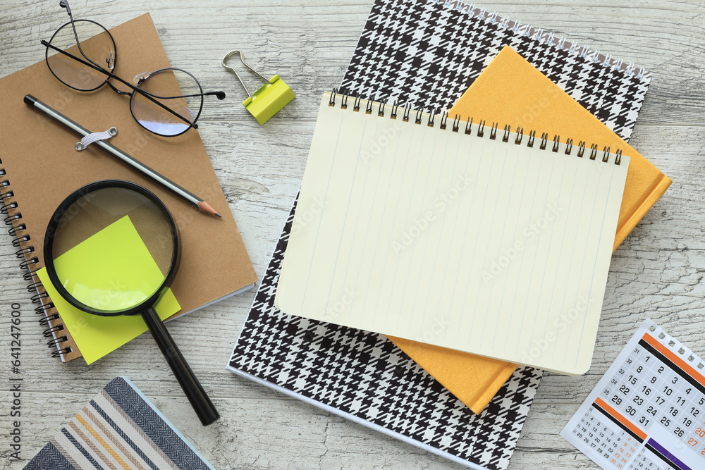 Poster office desk with notepad, bright yellow notepad and sticker magnifier. top view with copy space