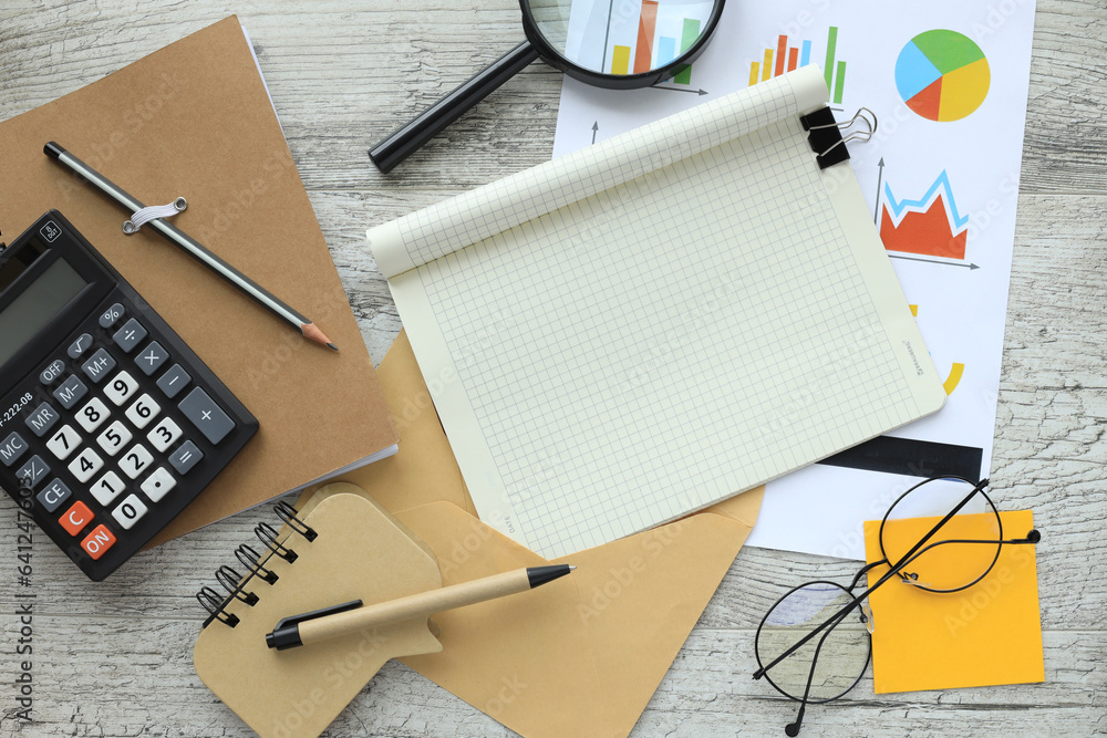 Poster calculator on a notepad. an empty notepad with a pen lies on a wooden office table. financial charts