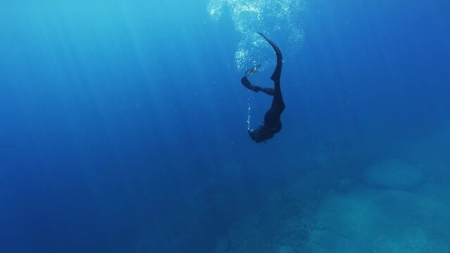 Underwater Slow Motion Footage of Free Diver Exploring Deep Ocean. Free Diving Recreation Sport.