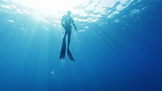 Underwater Slow Motion Footage of Free Diver Exploring Deep Ocean. Free Diving Recreation Sport.