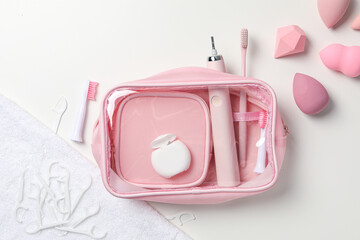Electric toothbrush, cosmetic bag and cosmetic sponges on white background, top view