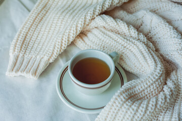 Home decor. Knitted blanket, cup of hot tea. Cozy autumn.