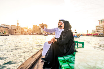 Middle eastern couple of lovers wearing traditional emirati clothing dating outdoors in Dubai -...
