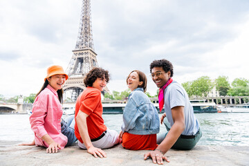 Group of young happy friends visiting Paris and Eiffel Tower - Multiethnic teens bonding outdoors...