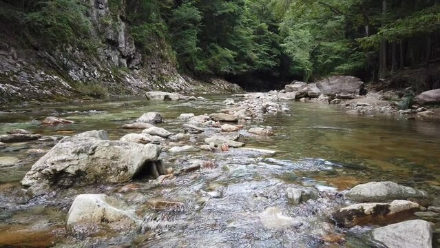 A view of a Japanese Zen River Landscape, Water Flowing Through Forest Stones around Minerales like Iron, used for Sento and Onzen Baths
