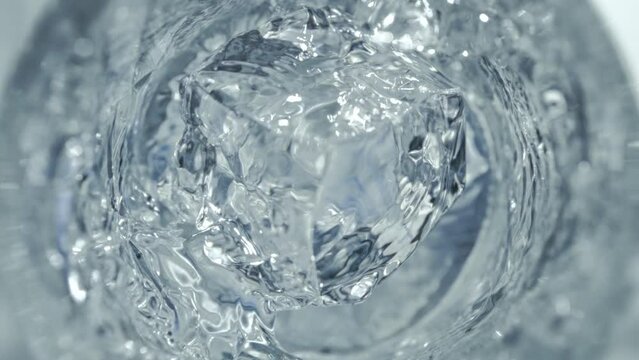 Super Slow Motion Detail Shot of Ice Cube Falling into Glass with Vodka at 1000 fps.