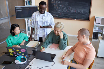 Team of highschool students brainstorming while preparing presentation of new project of decoding data or developing software at lesson