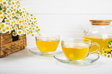 Herbal tea with fresh chamomile flowers on textured background. Calming and relaxing drink....