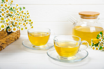 Herbal tea with fresh chamomile flowers on textured background. Calming and relaxing drink....