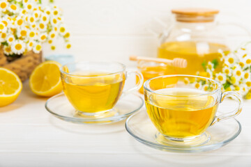 Herbal tea with fresh chamomile flowers on textured background. Calming and relaxing drink....