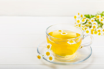 Herbal tea with fresh chamomile flowers on textured background. Calming and relaxing drink. Immunity.Cup of hot chamomile tea. Tea drinking concept. Tea ceremony. Place for text, copy space.