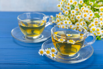 Herbal tea with fresh chamomile flowers on textured background. Calming and relaxing drink. Immunity.Cup of hot chamomile tea. Tea drinking concept. Tea ceremony. Place for text, copy space.