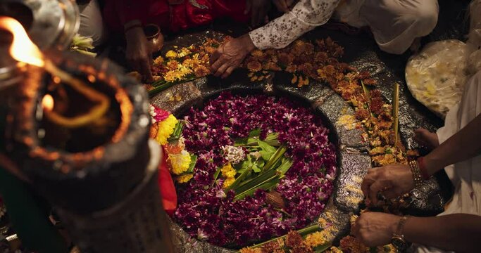 Hindu Religious Ceremony: Slow Motion of Group of Anonymous People Arranging Flowers Next to an Idol During a Shiva Aarti Ritual in a Temple. Devoted Indian Worshipers Praying to Their Deity 