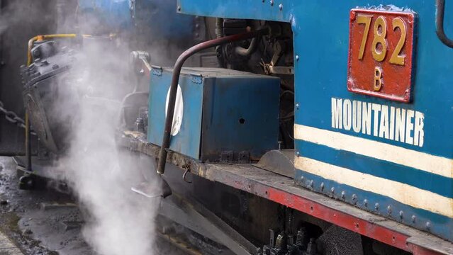 close up shot showing steam coming from the coal furnace boiler in the toy train in darjeeling showing this tourist attraction and ride that goes from Darjeeling to Ghum