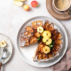 Homemade tarte tatin pie with apples and nuts on a beige background.