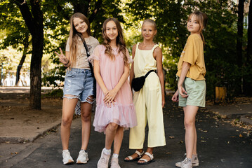 Little funny girls walking in the park on a beautiful summer day