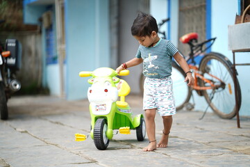 cute indian kid, indian boy enjoy cycle riding, Little Indian kid playing in a house stock images
