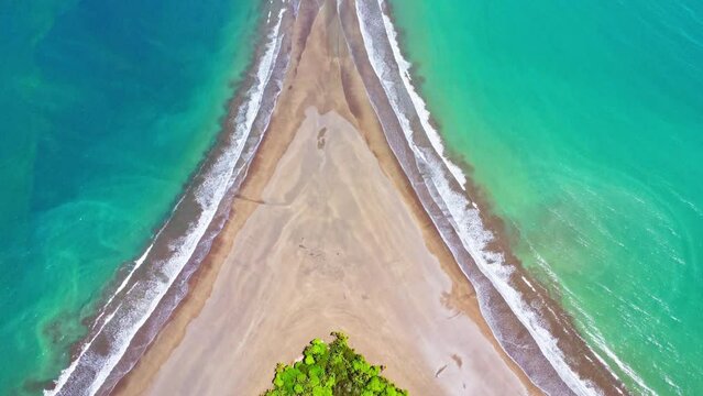 Aerial drone footage revealing a beach shaped like a whale's tail in Ballena Marine National Park, Costa Rica