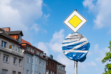 Road sign wrapped in plastic film against a background of blue sky with light clouds. Close up.