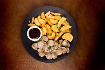 portion of finger food with bratwurst bratwurst fried sausages and potatoes and barbecue sauce top...