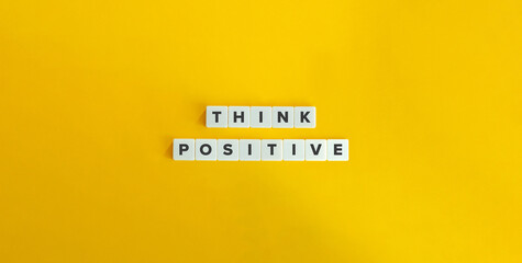 Think Positive, Optimism Concept. Letter Tiles on Yellow Background. Minimal Aesthetic.