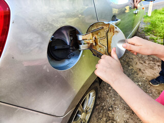 Hand of child Opening the fuel tank lid. Downloading, stealing gasoline from a car. Prank, pampering, wrecking