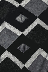 Realistic vector illustration abstract fabric texture.Detailed inserts in black genuine leather on a knitted woolen background with an abstract pattern.