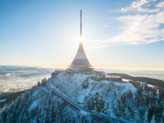 Jested mountain with modern hotel and TV transmitter on the top, Liberec, Czech Republic. Sunny winter day with snowy landscape. Aerial view from drone.
