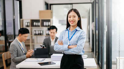 Young attractive Asian female office worker business suits smiling at camera in office .