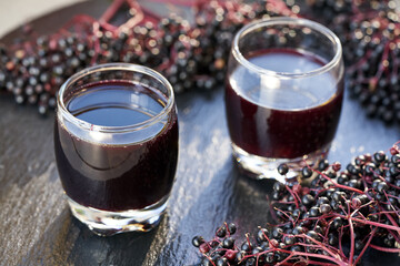 Two glasses of black elderberry syrup