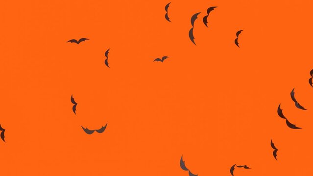 halloween background with flying spooky bats on the orange background.