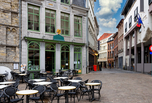 Old narrow street with tables of cafe in Ghent (Gent), Belgium. Architecture and landmark of Ghent. Cozy cityscape of Ghent.