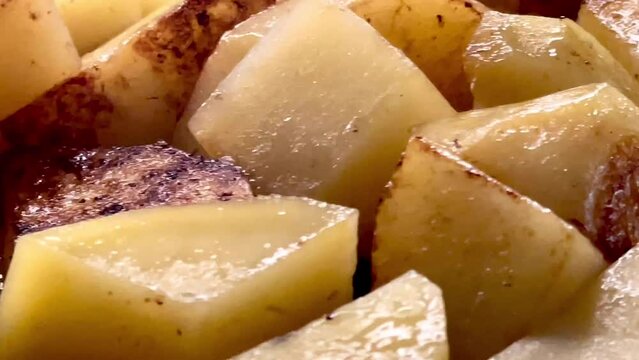 Diced potatoes frying on a pan, chips cooking process for recipe, homemade comfort food and dinner preparation, slow motion