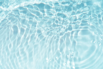 Blue water with ripples on the surface. Defocus blurred transparent blue colored clear calm water surface texture with splashes and bubbles. Water waves with shining pattern texture background.