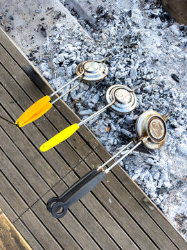 Three jaffle irons cooking on the coals