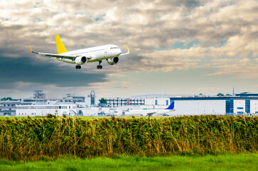 Airplane with landing gear in the sky with clouds. Flying passenger plane is landing at airport...